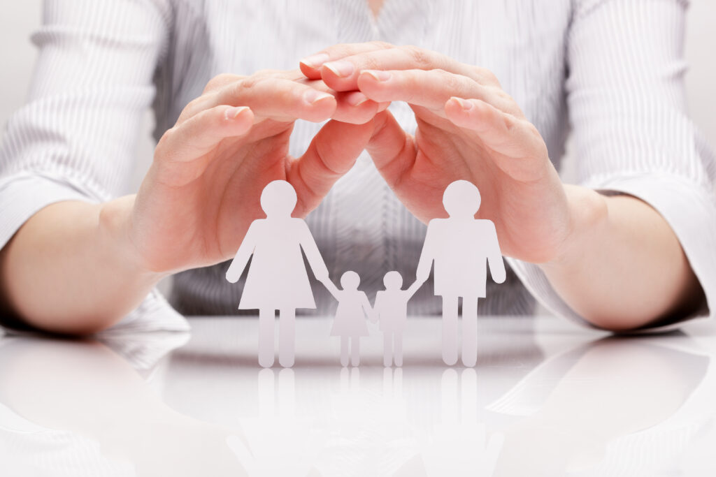 hands protecting cut out of family