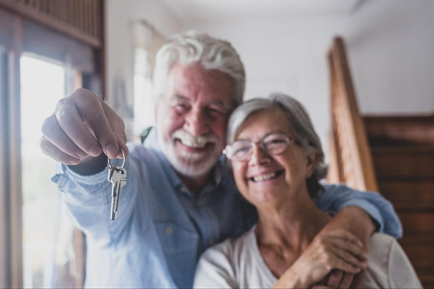 Mature couple with keys to new home
